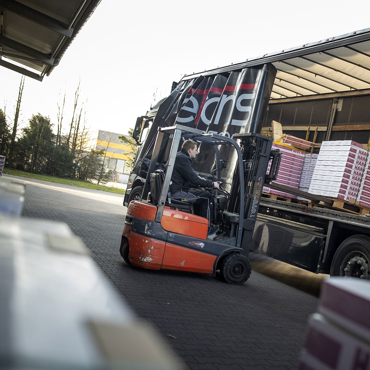 Böden werden vom LKW ins Lager transportiert Eine Boden-Lieferung wird per Gabelstapler vom LKW geladen