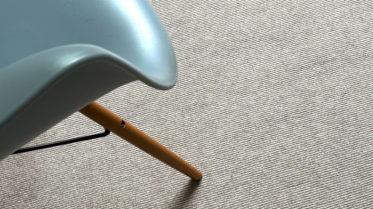 Kann man Teppichboden als Trittschalldämmung für Laminatboden nutzen? Teppichboden mit einem Designstuhl